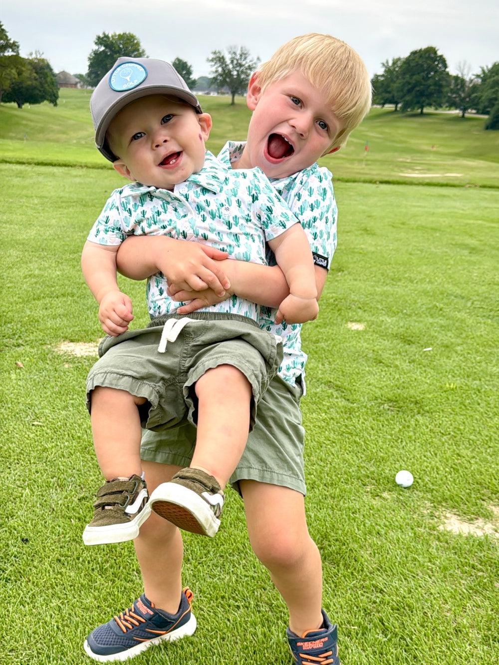 Two young boys playing on a grassy field.